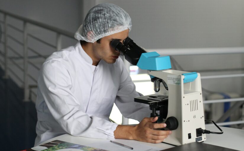 man viewing microscope in lab